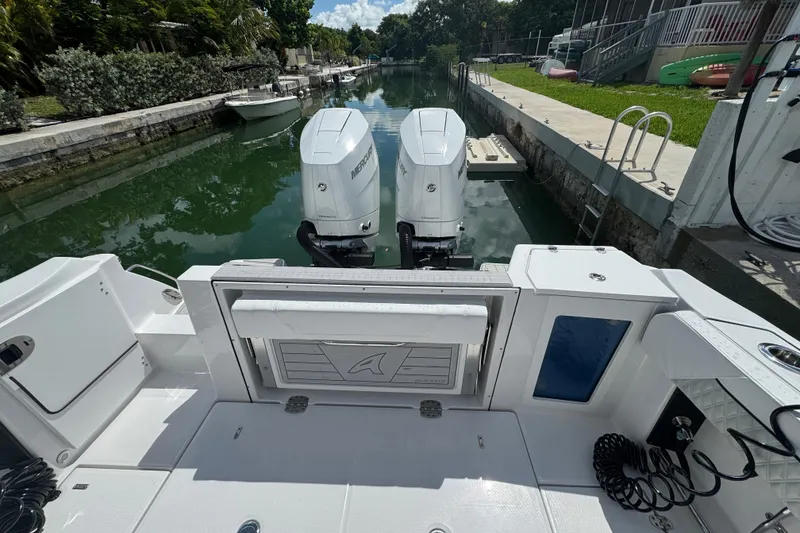 Slide: The Image of 2024 Blackfin 332 CC boat with twin Mercury engines docked in a canal. - 16