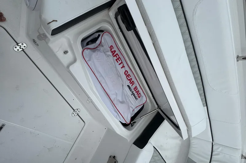 Slide: The Image of 2024 Blackfin 332 CC boat safety gear compartment with labeled bag. - 17