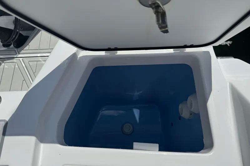 Slide: The Image of Open storage compartment on 2024 Blackfin 332 CC boat, featuring a blue interior. - 26
