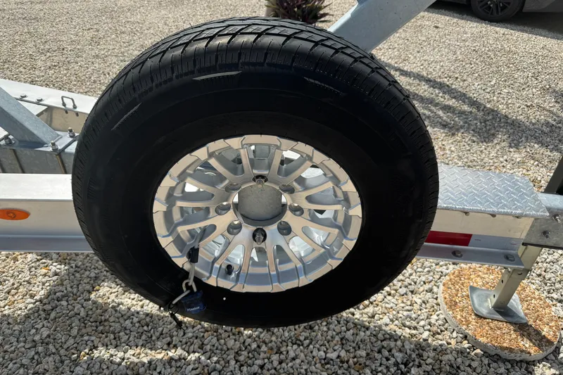 Slide: The Image of Trailer wheel on gravel, part of 2024 Blackfin 332 CC boat trailer. - 27