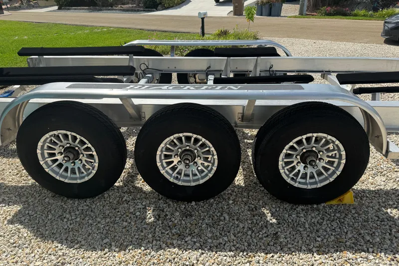 Slide: The Image of Triple-axle trailer for 2024 Blackfin 332 CC boat on gravel surface. - 30
