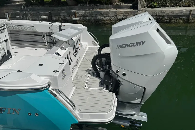 Slide: The Image of 2024 Blackfin 332 CC boat with Mercury outboard engines, docked in a serene setting. - 8