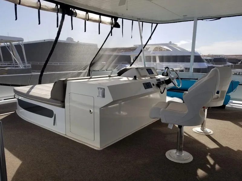Slide: The Image of Helm of 2016 Bravada Epic Journey houseboat, featuring modern controls and seating. - 5