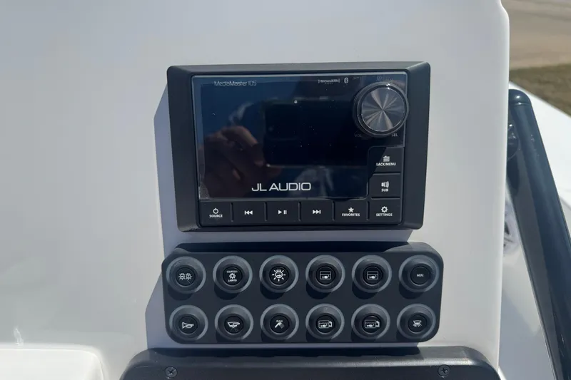 Slide: The Image of 2026 Blazer 675 Ultimate Bay audio control panel with JL Audio system and switches. - 12