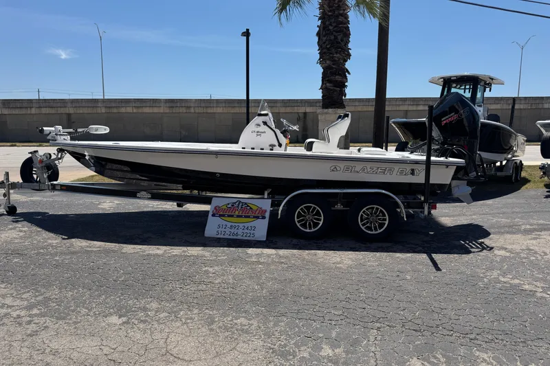 Slide: The Image of 2026 Blazer 675 Ultimate Bay boat on trailer, parked outdoors under clear sky. - 40