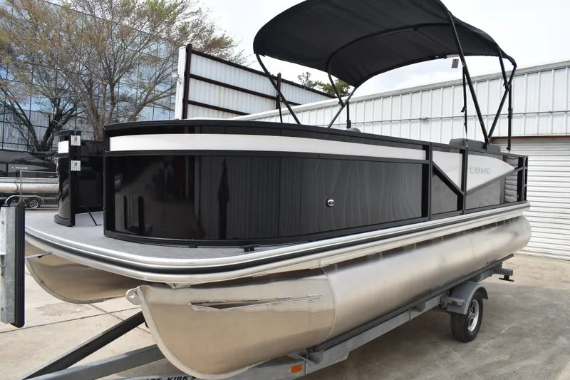 Slide: The Image of 2026 Lowe LF 214 pontoon boat with canopy on trailer, parked outdoors. - 7