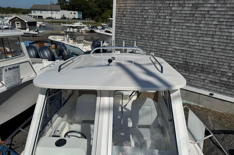 Slide: The Image of 2026 NorthCoast 235 HT boat docked, showcasing sleek design and spacious interior. - 12