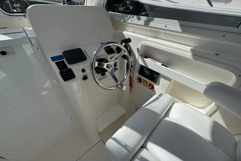 Slide: The Image of Interior helm of 2026 NorthCoast 235 HT boat with steering wheel and controls. - 16