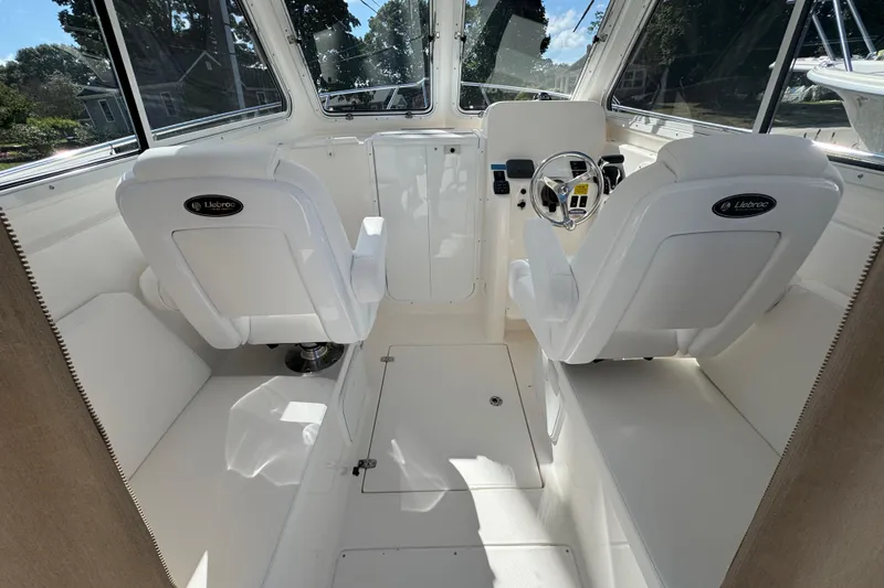 Slide: The Image of Interior of 2026 NorthCoast 235 HT boat with white seating and steering console. - 18