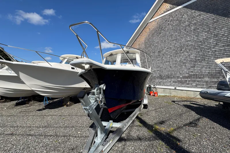 Slide: The Image of 2026 NorthCoast 235 HT boat on trailer, parked outdoors under clear blue sky. - 21