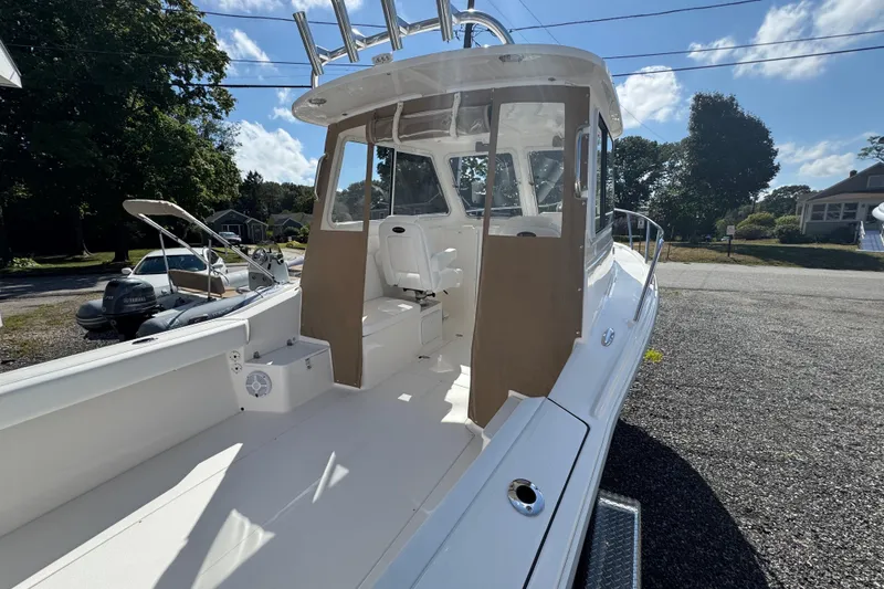 Slide: The Image of 2026 NorthCoast 235 HT boat with spacious deck and modern design, parked outdoors. - 25