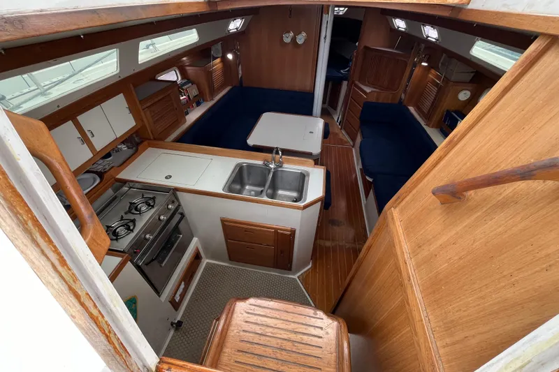 Slide: The Image of Interior of 1993 Catalina 36 sailboat with kitchen, seating, and wooden finishes. - 17
