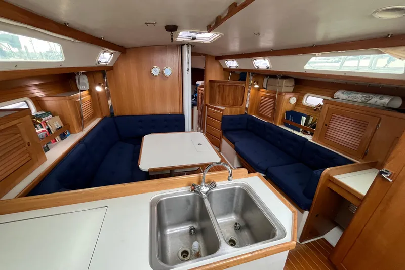 Slide: The Image of Interior of a 1993 Catalina 36 sailboat with blue seating and wooden cabinetry. - 18