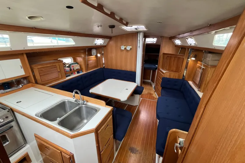 Slide: The Image of Interior of 1993 Catalina 36 sailboat with wood finish and blue seating. - 19