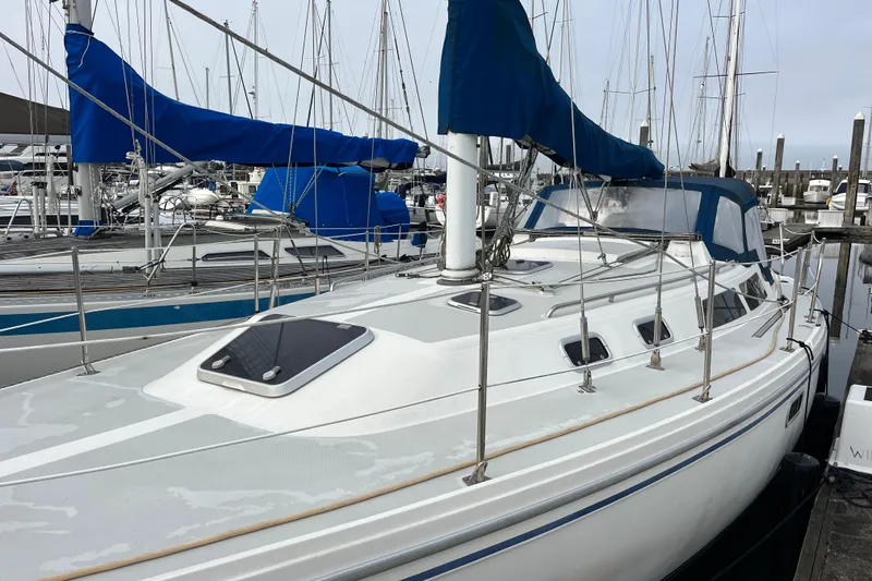 Slide: The Image of 1993 Catalina 36 sailboat docked in marina, featuring blue sail covers and sleek design. - 2