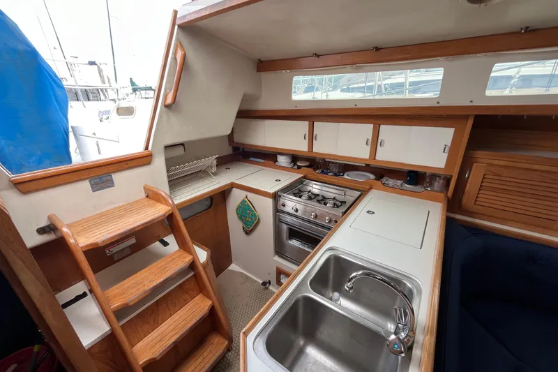 Slide: The Image of Interior of 1993 Catalina 36 sailboat kitchen with stove, sink, and wooden cabinetry. - 25