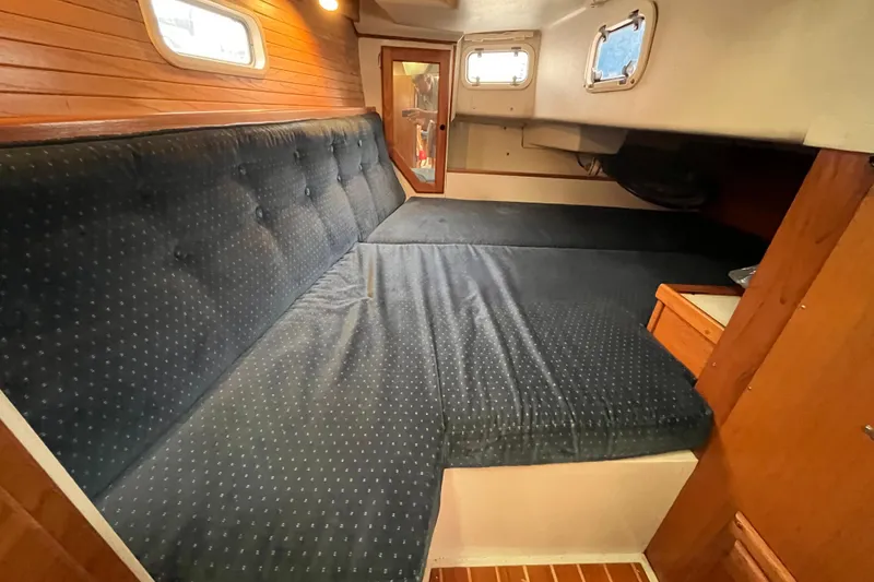 Slide: The Image of Interior cabin of a 1993 Catalina 36 sailboat with blue cushioned seating. - 27