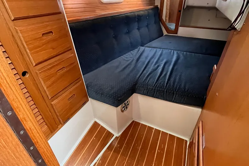 Slide: The Image of Interior of 1993 Catalina 36 sailboat with wooden cabinetry and blue cushioned seating. - 28