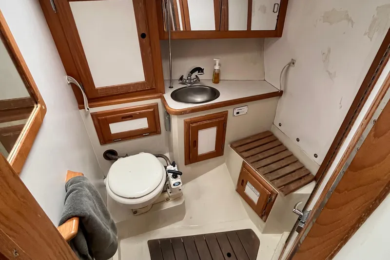 Slide: The Image of Bathroom interior of 1993 Catalina 36 sailboat with wooden cabinetry and compact design. - 29