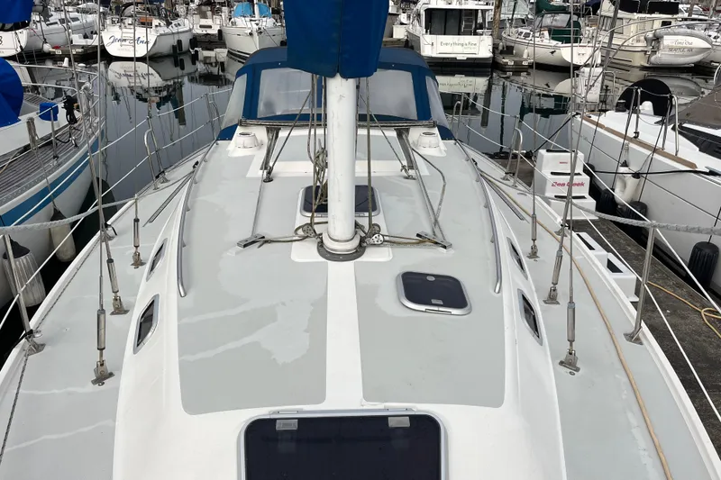 Slide: The Image of 1993 Catalina 36 sailboat docked in a marina, surrounded by other boats. - 4