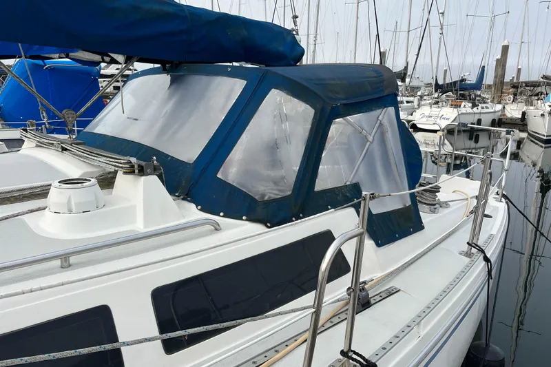 Slide: The Image of 1993 Catalina 36 sailboat with blue canopy docked in marina. - 7