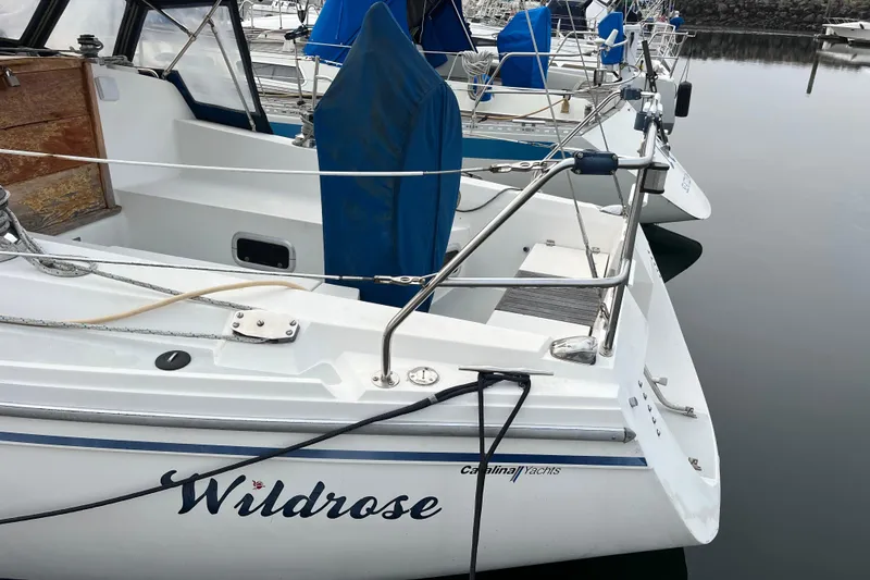 Slide: The Image of Catalina 36 sailboat "Wildrose" docked, 1993 model, with blue covers and calm water reflection. - 8