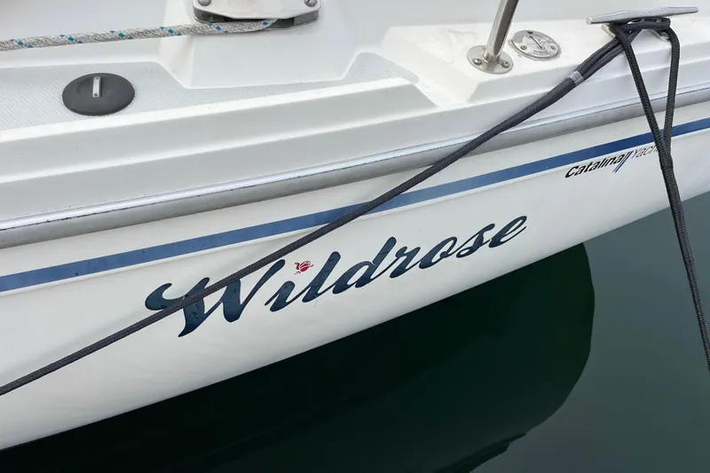 Slide: The Image of 1993 Catalina 36 sailboat named "Wildrose" docked with visible rope and branding. - 9