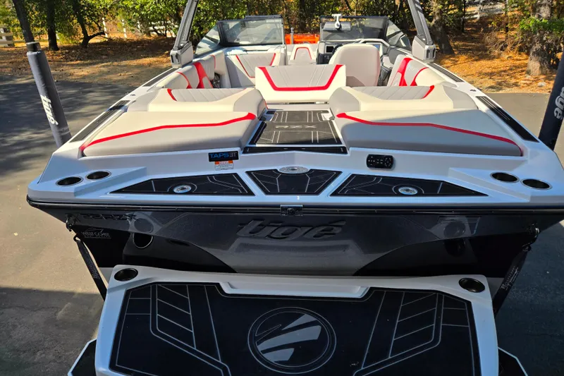 Slide: The Image of 2021 Tigé 22RZX boat with sleek design and comfortable seating, parked outdoors. - 5