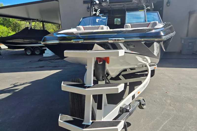 Slide: The Image of 2021 Tigé 22RZX boat on trailer, parked outdoors in sunny setting. - 6