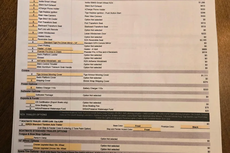Slide: The Image of 2021 Tigé 22RZX boat options list with pricing details on a wooden table. - 9