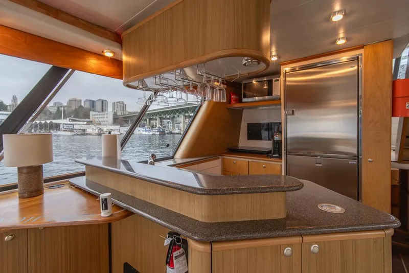 Slide: The Image of Interior of 2000 Bayliner 4788 Pilot House Motoryacht with modern kitchen and waterfront view. - 17