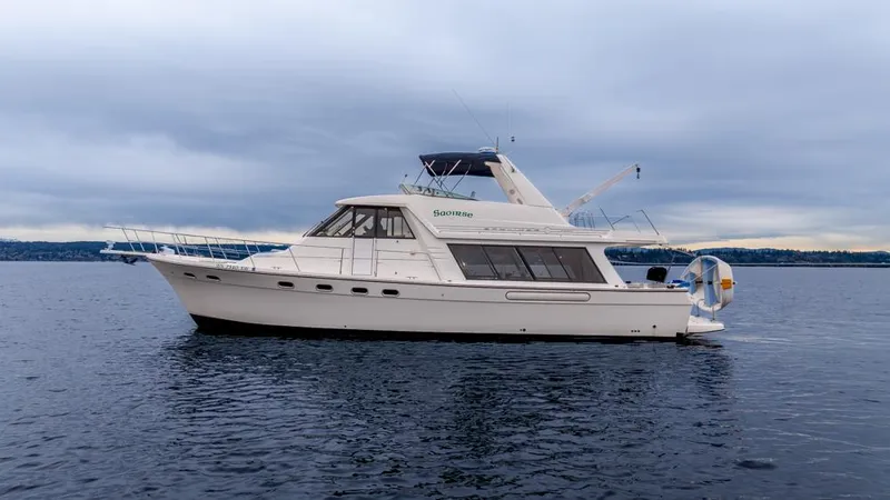 Slide: The Image of 2000 Bayliner 4788 Pilot House Motoryacht on calm water under cloudy sky. - 2