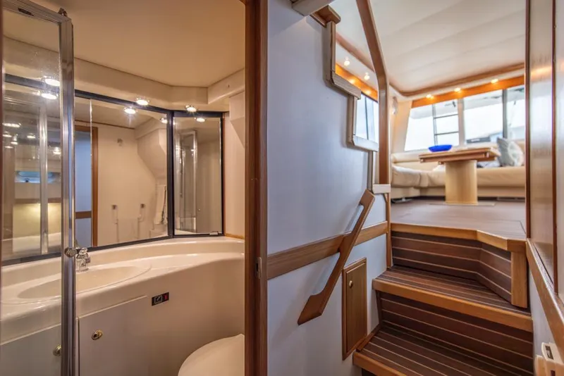 Slide: The Image of Interior of 2000 Bayliner 4788 Pilot House Motoryacht, featuring stairs and a modern bathroom. - 31
