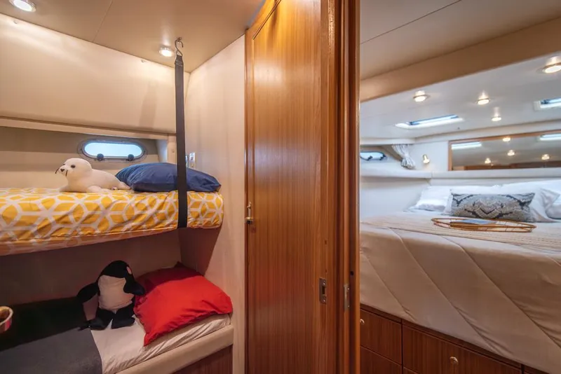 Slide: The Image of Cozy cabin interior of 2000 Bayliner 4788 Pilot House Motoryacht with bunk beds and plush decor. - 33