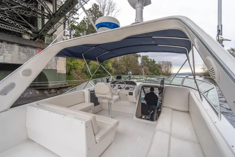 Slide: The Image of 2000 Bayliner 4788 Pilot House Motoryacht with spacious deck and seating under a canopy. - 48