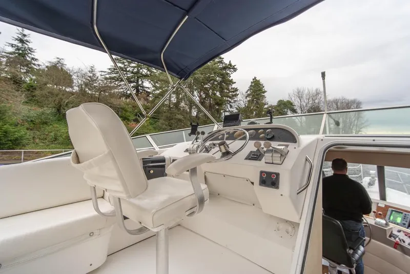 Slide: The Image of Bayliner 4788 Pilot House Motoryacht 2000 helm with white seating and navigation controls. - 49