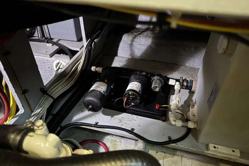 Slide: The Image of Engine compartment of a 2002 Silverton 352 Motor Yacht, showcasing wiring and pump system. - 102