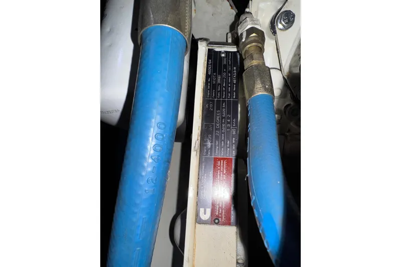 Slide: The Image of Engine compartment of 2002 Silverton 352 Motor Yacht with blue hoses and label. - 119