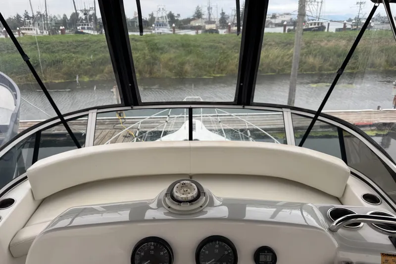 Slide: The Image of 2002 Silverton 352 Motor Yacht helm with river view and docked boats. - 22