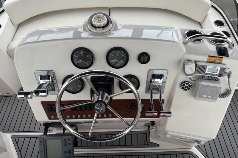 Slide: The Image of 2002 Silverton 352 Motor Yacht helm with steering wheel, gauges, and controls. - 26
