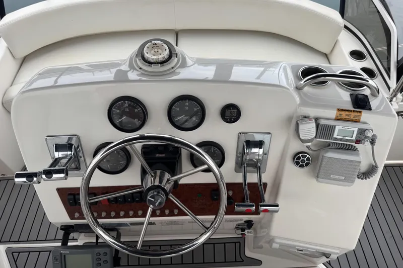 Slide: The Image of 2002 Silverton 352 Motor Yacht helm with steering wheel, gauges, and communication equipment. - 27