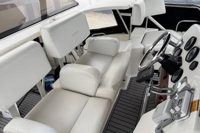 Slide: The Image of 2002 Silverton 352 Motor Yacht cockpit with white seating and control panel. - 29