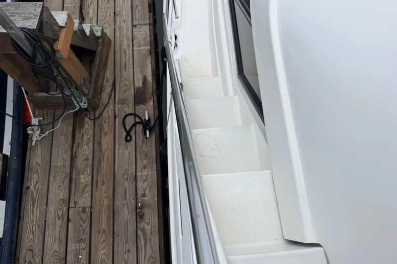 Slide: The Image of 2002 Silverton 352 Motor Yacht docked, showing side steps and wooden pier. - 45