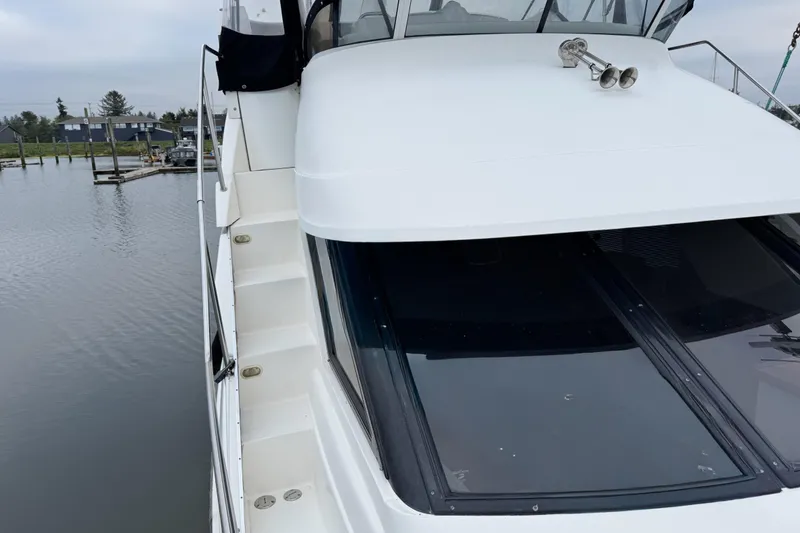 Slide: The Image of 2002 Silverton 352 Motor Yacht docked, showcasing sleek design and spacious deck area. - 48