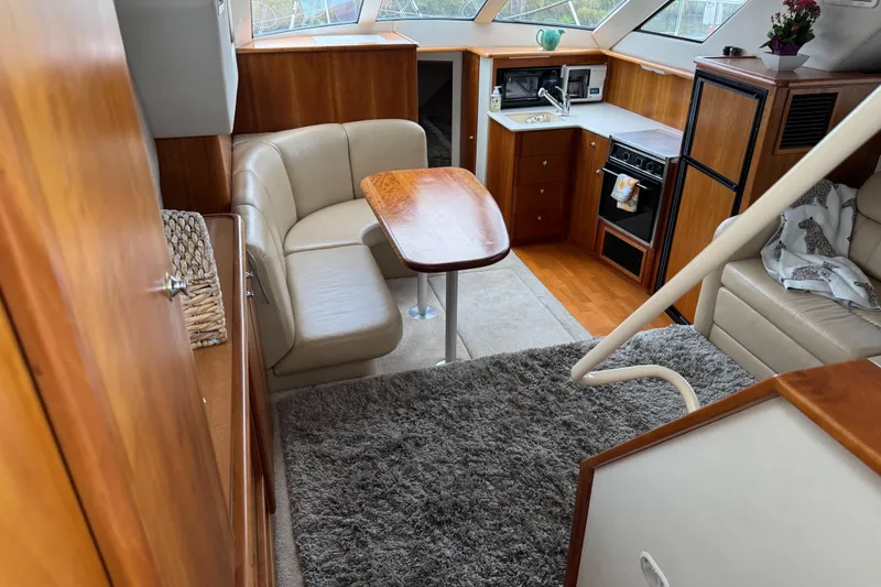 Slide: The Image of Interior of 2002 Silverton 352 Motor Yacht with cozy seating and kitchen area. - 56