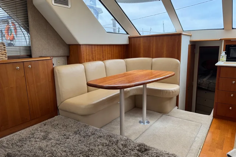 Slide: The Image of Interior of 2002 Silverton 352 Motor Yacht with beige seating and wooden table. - 66