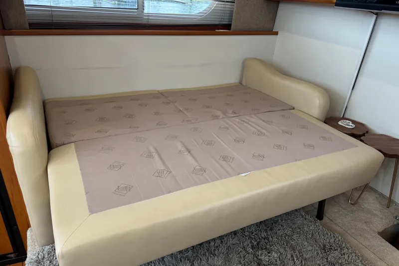 Slide: The Image of 2002 Silverton 352 Motor Yacht interior with beige sofa bed and cozy decor. - 68