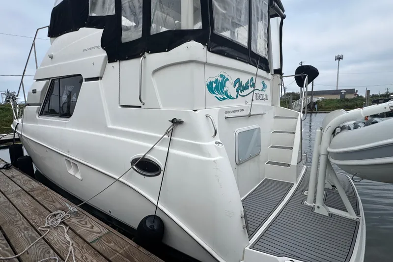 Slide: The Image of 2002 Silverton 352 Motor Yacht docked with inflatable boat attached. - 7