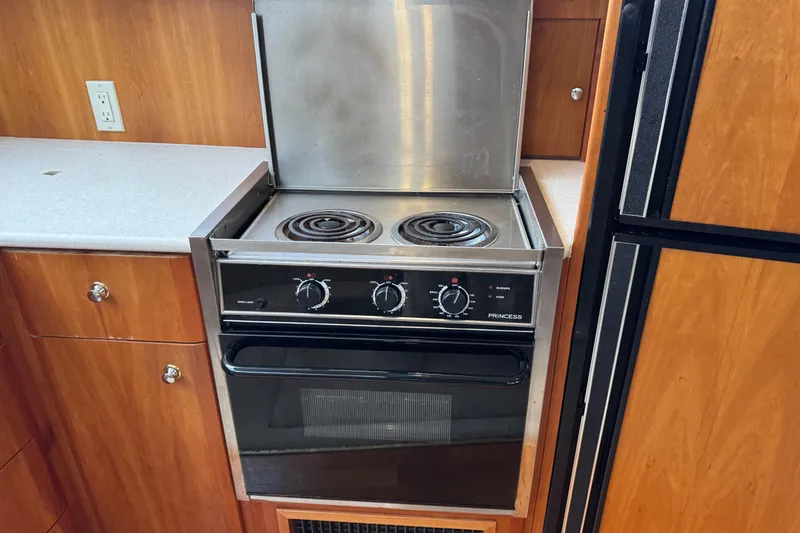 Slide: The Image of 2002 Silverton 352 Motor Yacht kitchen with stove and wooden cabinetry. - 72