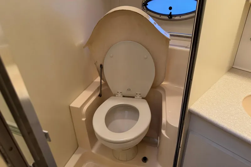 Slide: The Image of 2002 Silverton 352 Motor Yacht bathroom with toilet and porthole window. - 78